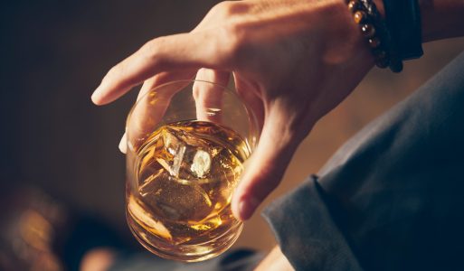 high angle closeup shot male holding glass whiskey scaled